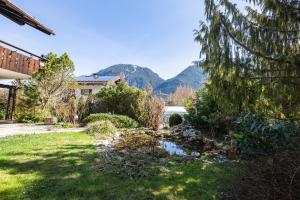 een tuin met een beekje in de tuin met bergen op de achtergrond bij Bergrose in Farchant