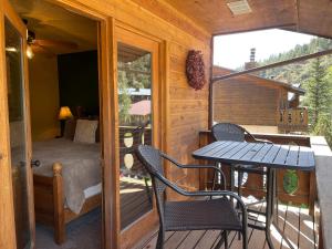 um quarto com uma cama e uma mesa e cadeiras numa varanda em Mountain Memories With High Speed Wifi em Red River