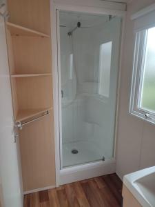 a shower with a glass door in a bathroom at Mobil-home Alsace in Biesheim