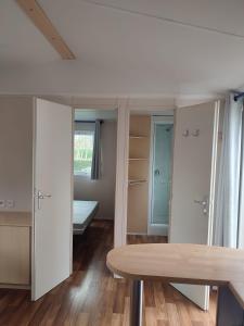 a room with white cabinets and a wooden table at Mobil-home Alsace in Biesheim