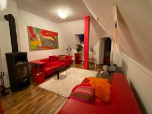 a living room with red furniture and a red couch at Ferienwohnung in historischer Villa mit Gartennutzung in Furth im Wald