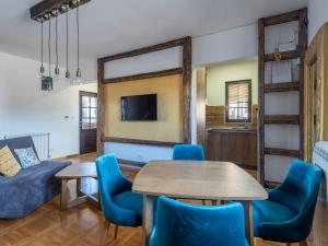 茲拉蒂博爾的住宿－Velika Recepcija 10，客厅配有桌子和蓝色椅子