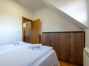 Velika Recepcija 10 في زلاتيبور: غرفة نوم بسريرين وخزانة خشبية