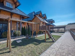 a playground in front of a wooden house at Velika Recepcija 10 in Zlatibor