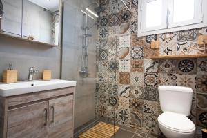 a bathroom with a toilet and a sink and a shower at Sea & Mountain House in Nótos +20 photos