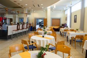 a restaurant with tables and chairs and a counter at Hotel Szieszta in Sopron