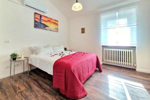 een slaapkamer met een bed met een rode deken erop bij [Idromassaggio & BBQ]wifi, relax e private parking in Sirolo