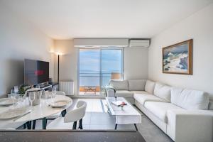 a living room with a white couch and a table at Baie Roquebrune, Balcon Vue Mer, Parking Gratuit - AO in Roquebrune-Cap-Martin