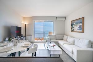 salon z białą kanapą i stołem w obiekcie Baie Roquebrune, Balcon Vue Mer, Parking Gratuit - AO w mieście Roquebrune-Cap-Martin