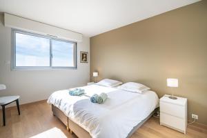 sypialnia z dużym białym łóżkiem i oknem w obiekcie Baie Roquebrune, Balcon Vue Mer, Parking Gratuit - AO w mieście Roquebrune-Cap-Martin