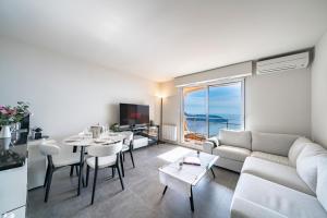 salon z kanapą i stołem w obiekcie Baie Roquebrune, Balcon Vue Mer, Parking Gratuit - AO w mieście Roquebrune-Cap-Martin