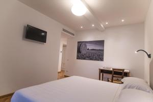 a bedroom with a white bed and a desk at Agriturismo Ai Prati in Perugia