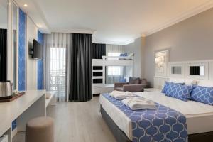a hotel room with a bed and a living room at Euphoria Barbaross Beach Resort in Kızılot
