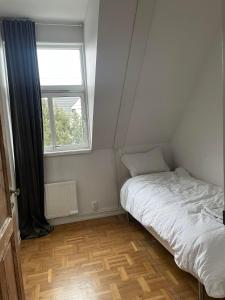 a small bedroom with a bed and a window at Apartment in historical house in Oslo