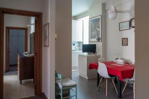 バーリにあるCasa dei Ruscelliの赤いテーブルと椅子、キッチンが備わる客室です。