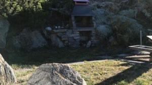 einen Felsen vor einem Steingebäude in der Unterkunft Appartement dans un chalet avec jardin in Nax