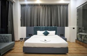 a bedroom with a king sized bed with a blue headboard at HOTEL THE PARKER INN By KBNT GROUP in Surat