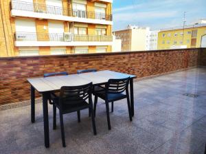 a table and chairs sitting on a roof at Ancla Spaces nuevo apt cerca del mar, sin vistas in Vinarós