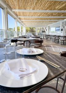 une table avec des assiettes, des verres et des tables blancs dans l'établissement Albergo Da Carmine, à Castellabate