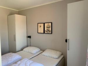 Duas camas num quarto com paredes brancas em Slåttastølen leiligheter - by Geilolia em Geilo