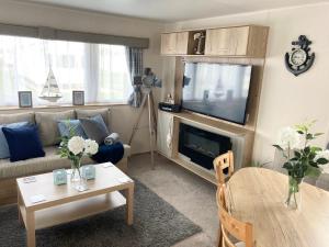 a living room with a couch and a tv at The Wardens Hideaway - Tattershall Lakes Country Park in Tattershall