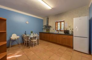 a kitchen with a table and a white refrigerator at Rapia. Casa Rosa 2 in Moratalla