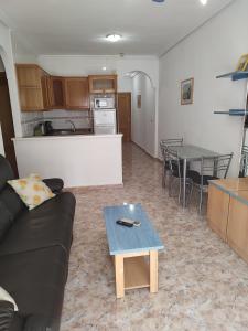 een woonkamer met een bank en een tafel bij Marina Sol in Cabo Roig