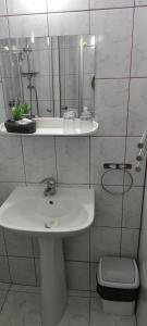 a white bathroom with a sink and a mirror at Hotel Zimbru in Cluj-Napoca