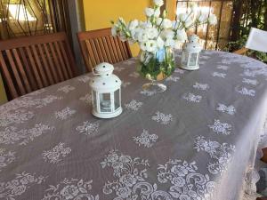 une table avec un vase de fleurs et des lanternes sur elle dans l'établissement Casamalu, à Lucques