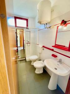 a bathroom with two toilets and a sink at Appartamento Eldorado in Marina di Bibbona