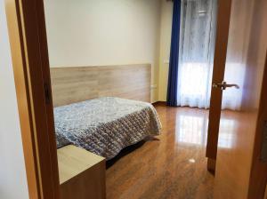 a bedroom with a bed and a wooden floor at Ancla Spaces nuevo apt cerca del mar, sin vistas in Vinarós