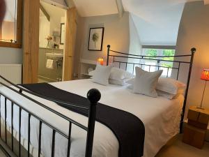 um quarto com uma cama grande e almofadas brancas em Spring Cottage B&B em Probus