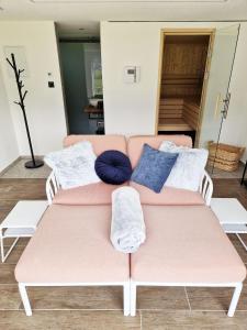- un canapé rose avec des oreillers dans le salon dans l'établissement Ferienwohnung Melanie, à Hart im Zillertal