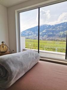 a bedroom with a large window with a view at Ferienwohnung Melanie in Hart im Zillertal