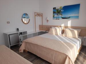 a bedroom with a bed and a table and a mirror at Anxhelos Hotel in Himare