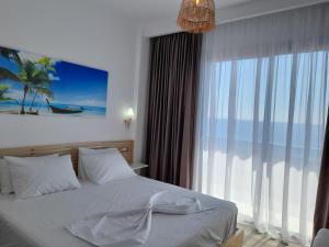 a bedroom with a bed and a large window at Anxhelos Hotel in Himare
