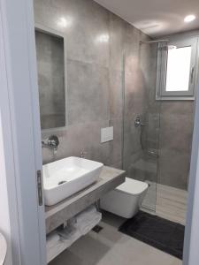 a bathroom with a sink and a toilet and a shower at Anxhelos Hotel in Himare