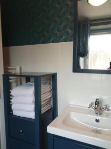 a bathroom with a sink and a mirror and towels at Les Hortensias 26 in Saint-Laurent-sur-Mer