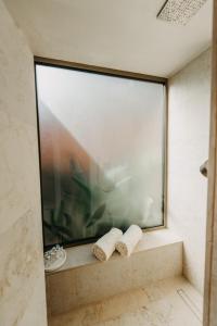 a bathroom with a large window and two rolled towels at Zori Timeless Hotel in Hvar