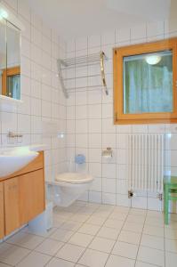 a bathroom with a sink and a toilet and a window at Ambiente Bettmeralp | A10 in Bettmeralp