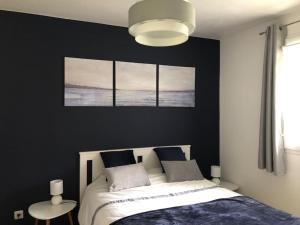 um quarto com uma cama com três fotografias na parede em Appartement F2 calme et élégant em Équemauville