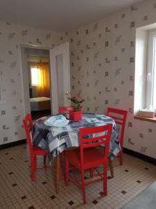 サン・ローラン・シュル・メールにあるLes Hortensiasのダイニングルーム(テーブル、赤い椅子付)