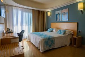 a hotel room with a bed and a large window at Taormina Panoramic Hotel in Taormina