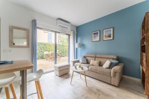 a living room with a couch and a table at Côté Port - Appt sortie privée vers le port in Arcachon