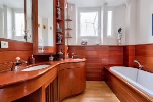 łazienka z dwiema umywalkami, wanną i lustrem w obiekcie Appartement de charme en centre-ville pour 6 pers. w mieście Nantes