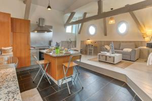 eine Küche und ein Wohnzimmer mit einem Tisch und Stühlen in der Unterkunft Le Bateau Perché - Bel appt pour 4 in Nay