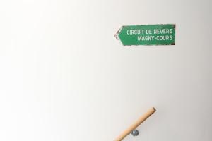 una señal colgando de una pared con un palo en Le Circuit - Tout simplement: confort!, en Cosne-Cours-sur-Loire