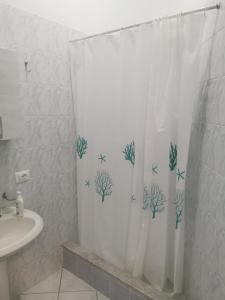 un baño con una cortina de ducha con peces estrella. en Casa Giusi en Sferracavallo