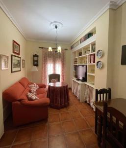 uma sala de estar com um sofá vermelho e uma mesa em Apartamento El convento em Almodóvar del Río