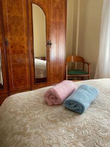 duas toalhas numa cama com uma cómoda e um espelho em Apartamento El convento em Almodóvar del Río